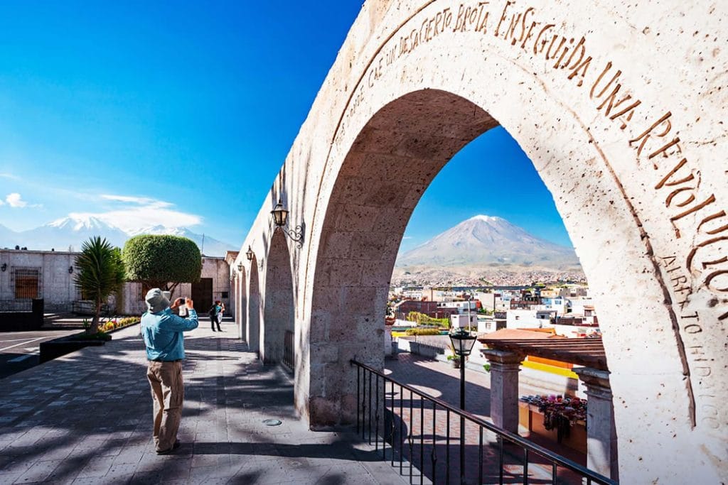 Vista icónica del imponente Volcán Misti, enmarcado por los arcos de sillar blanco del Mirador de Yanahuara, Arequipa.