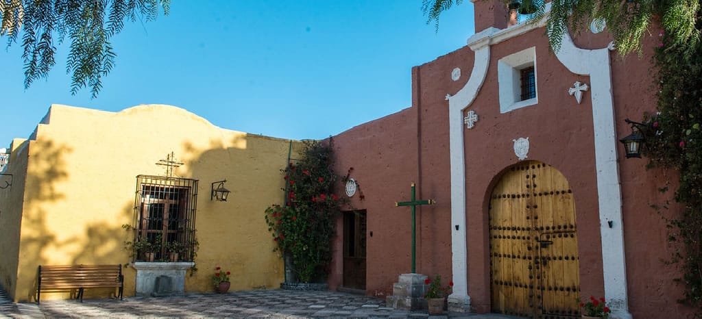Interior del icónico Monasterio de Santa Catalina en Arequipa, destacando las construcciones de sillar pintadas en rojo guinda y amarillo.