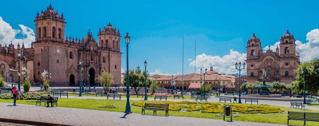 Vista desde la Plaza de Armas de Cusco, mostrando la Catedral y la Iglesia de la Compañía de Jesús y la composición colonial de la plaza central.