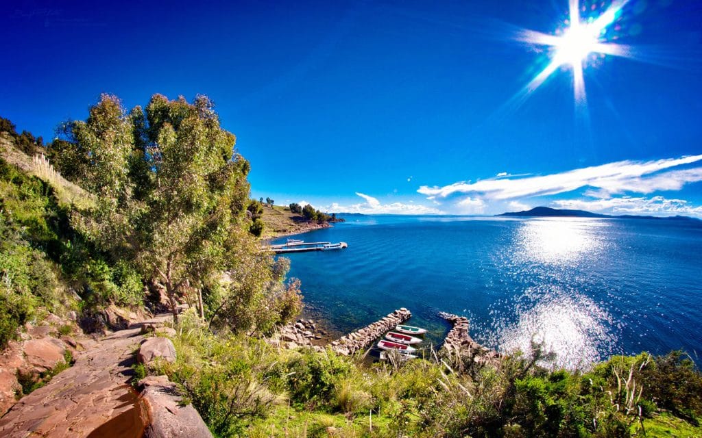 Vista panorámica del amanecer en el Lago Titicaca, capturada desde el sendero que desciende a uno de los puertos rústicos de la Isla Taquile.