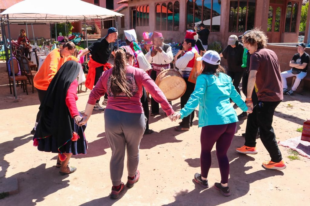 Encuentro cultural en Taquile: demostración de danza Sikuris donde los turistas se unen a los nativos en el baile.