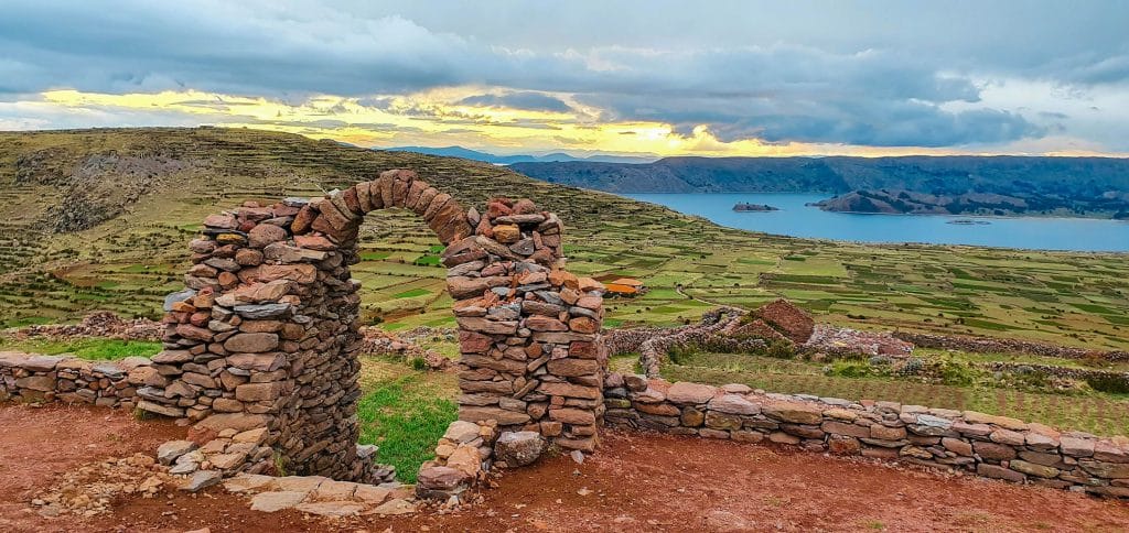 Espectacular atardecer sobre el Lago Titicaca, visto desde el arco de piedra del centro ceremonial Pachatata en la Isla Amantaní.