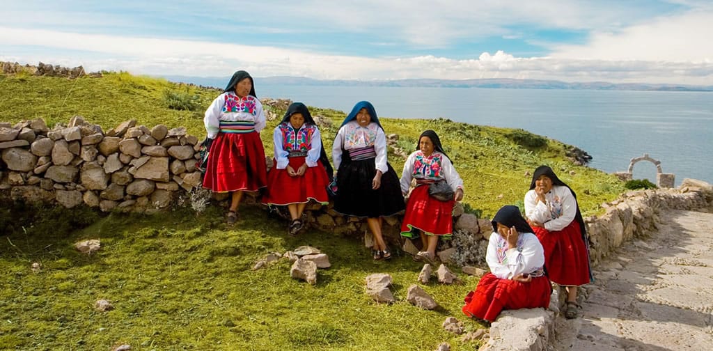 Grupo de mujeres descansando cerca al sitio ceremonial Pachamama en Amantaní, previo a la reunión cultural.