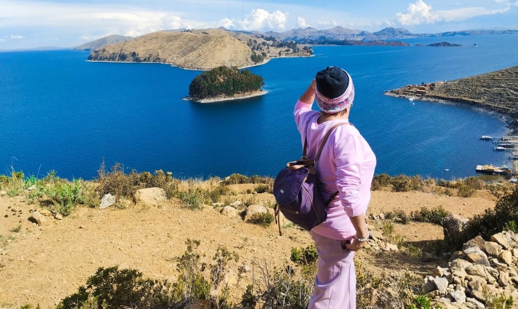 Turista observa el impresionante panorama del Lago Titicaca y las islas menores en el lado boliviano, tomada desde un sendero en la parte superior de la Isla del Sol.