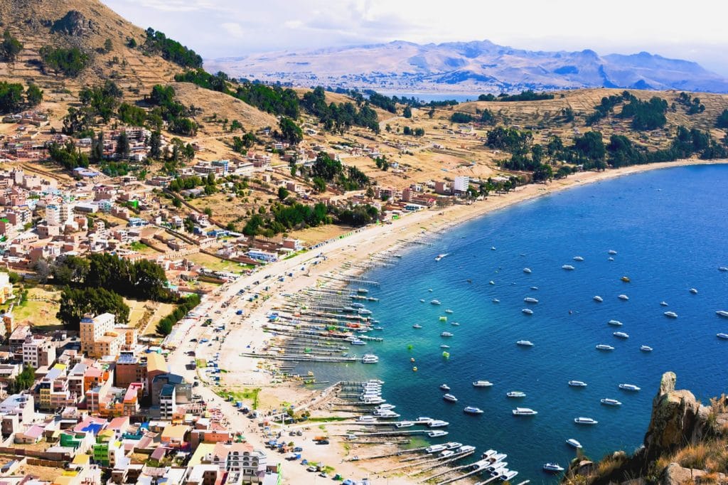 Vista panorámica de la Bahía de Copacabana y la ciudad enclavada a orillas del Lago Titicaca, mostrando el puerto y las laderas que descienden hacia el lago, en Bolivia.