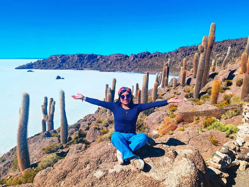 Vista de día de la Isla Incahuasi (Montaña de Cactus), cubierta de cactus gigantes, emergiendo como un oasis rocoso en medio de la inmensidad y el deslumbrante blanco del Salar de Uyuni.