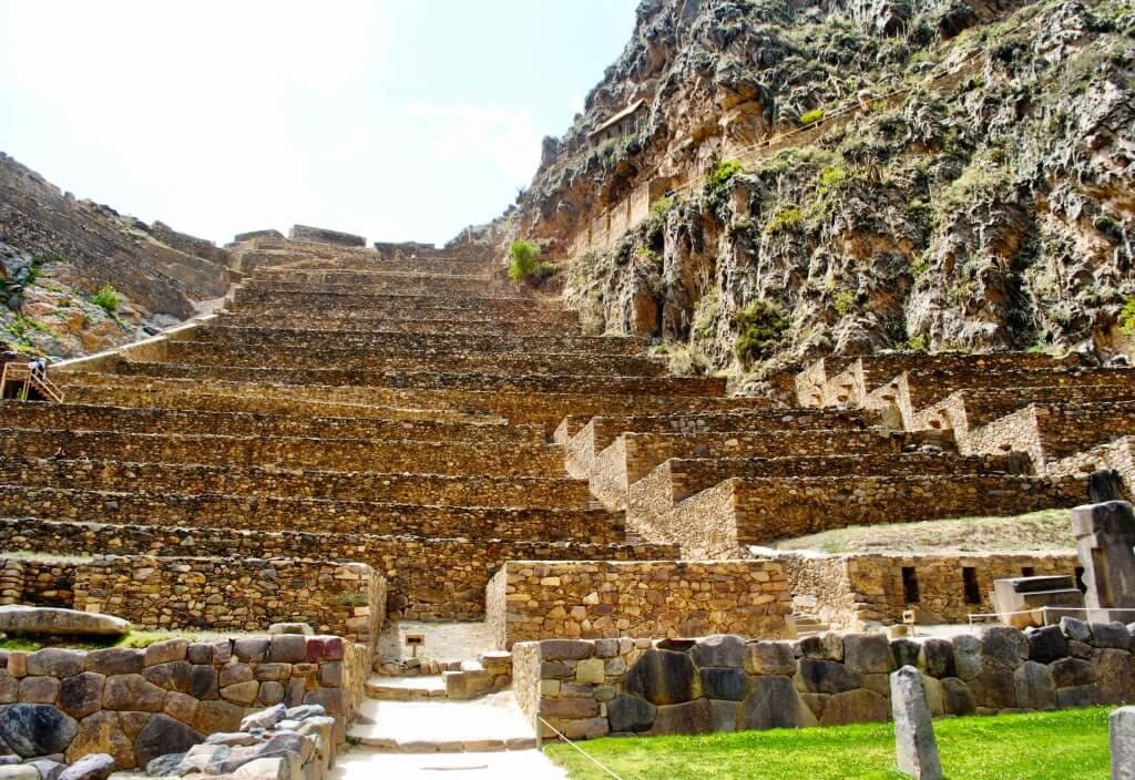Vista desde la base de la montaña de Pisac, donde las terrazas incas forman imponentes graderíos agrícolas que se elevan hacia el sitio arqueológico.