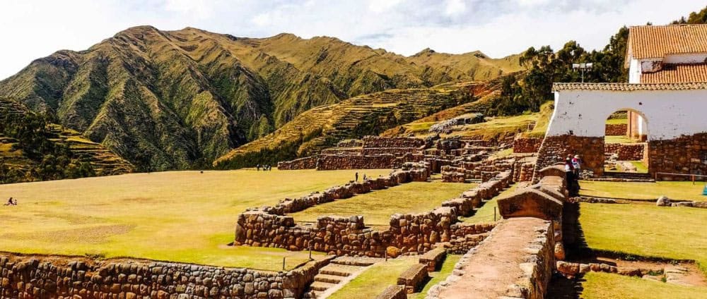 Explanada de Chinchero en el Valle Sagrado, con la iglesia colonial construida sobre la base de un muro o plaza inca, reflejando la fusión de culturas.