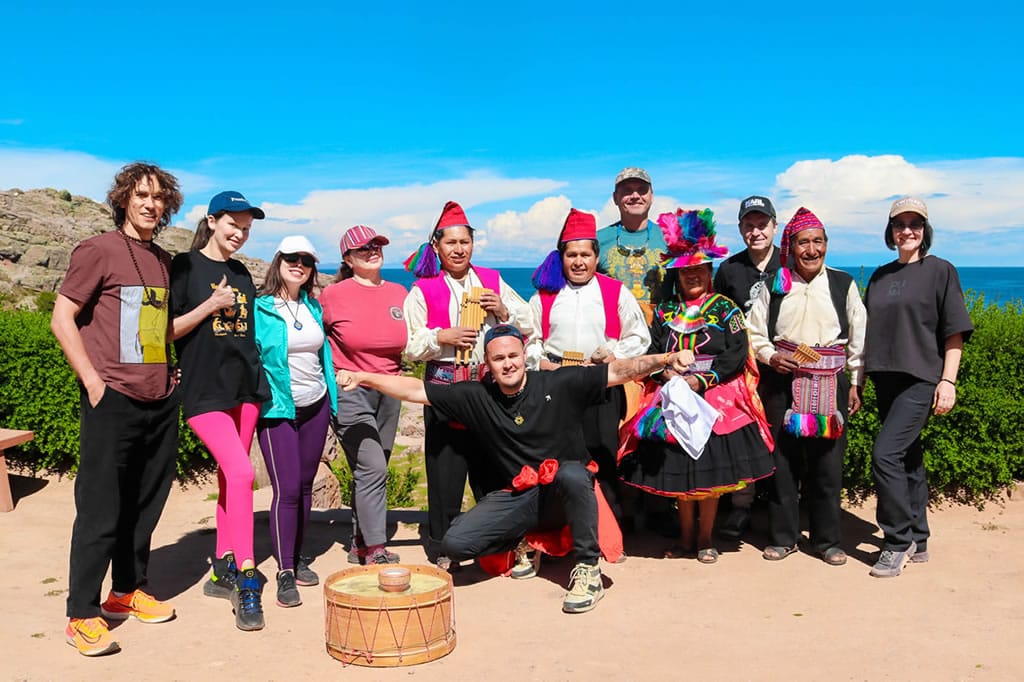 Pobladores de Taquile con vestimenta para la danza Sikuris posando para una foto grupal, antes o después de la demostración cultural.