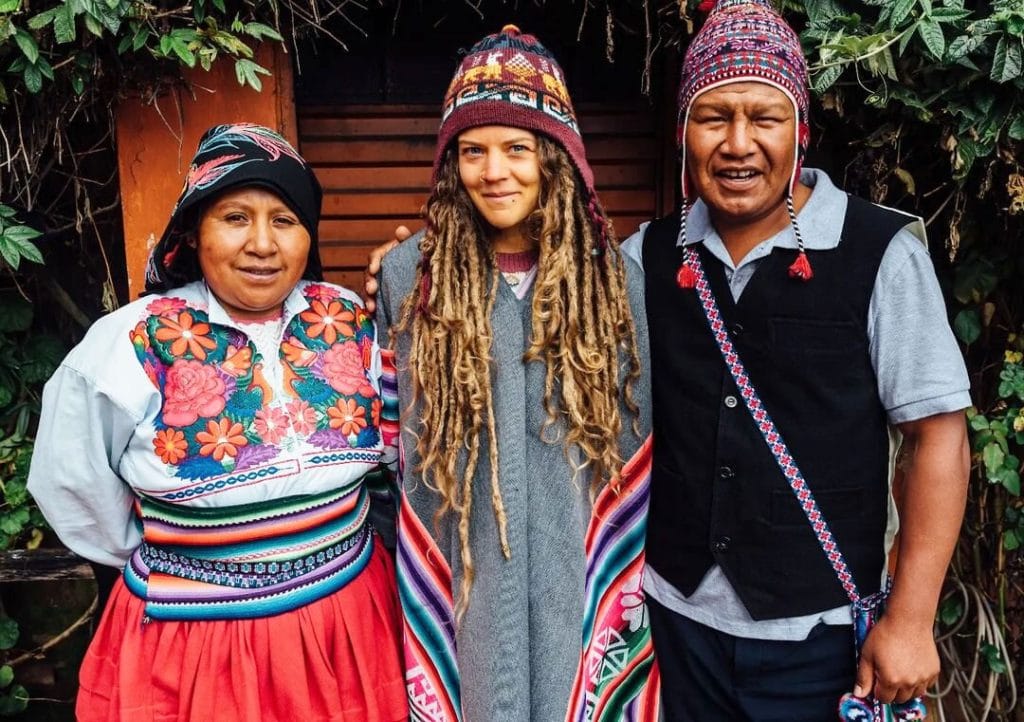Pareja de Taquile con vestimenta tradicional y turista en el tour Uros y Taquile Puno Tours.