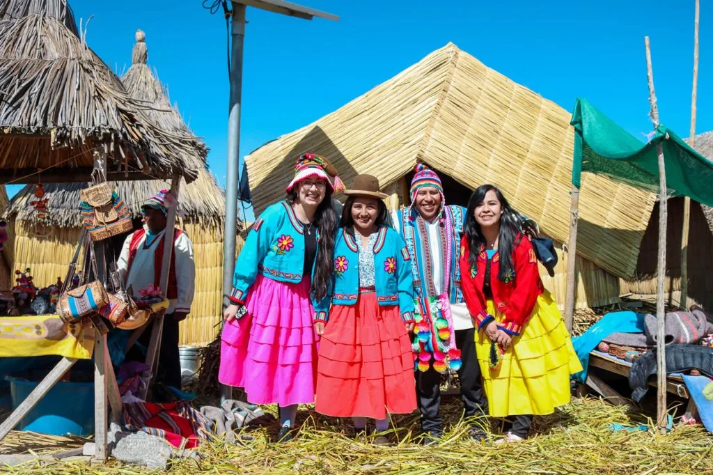 Encuentro de turistas con familia Uros en trajes tradicionales, Islas Flotantes Puno.