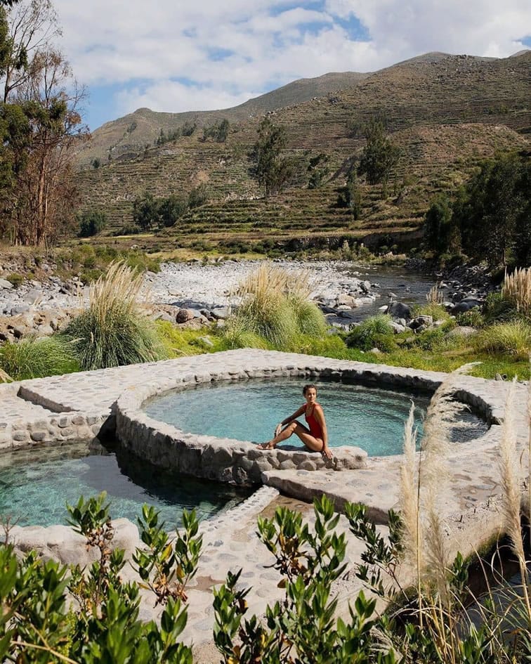 Pozas circulares de los baños termales de La Calera en Chivay, rodeadas de vegetación andina, destacando la infraestructura de relajación.